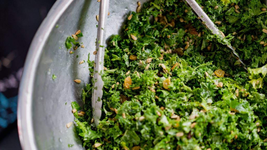 Green leafy vegetables salad in a stainless bowl.