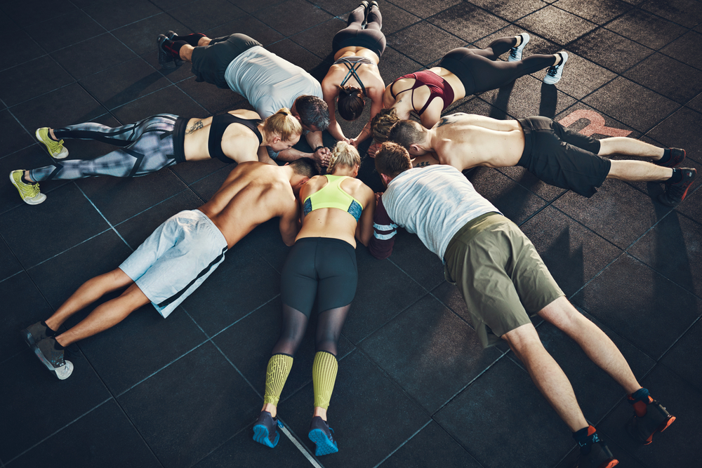 A fitness class doing planking in a circle.