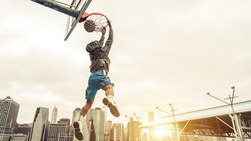 Man dunking a basketball. Doing basketball exercises as part of a cycled training plan.