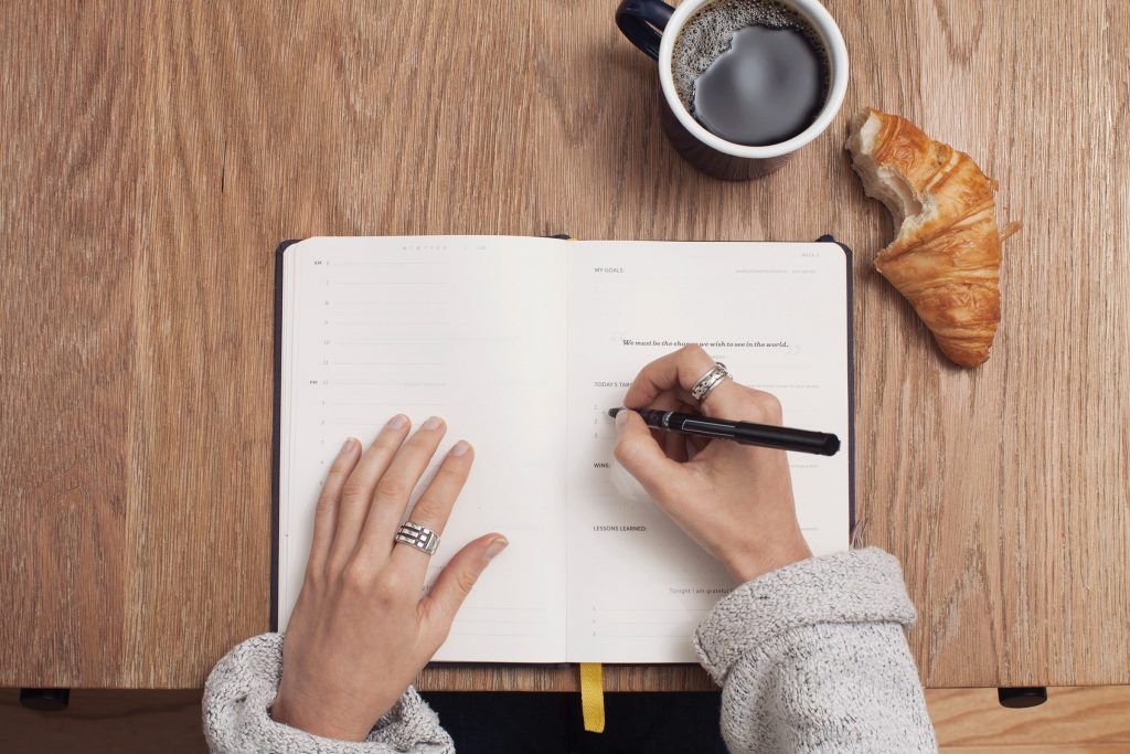 A woman writing on her journal.