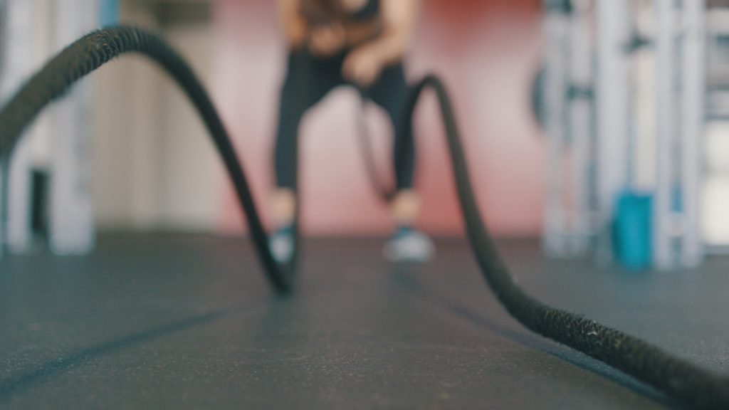 A blurred image of a person doing battle rope, which is best cardio for fat loss.