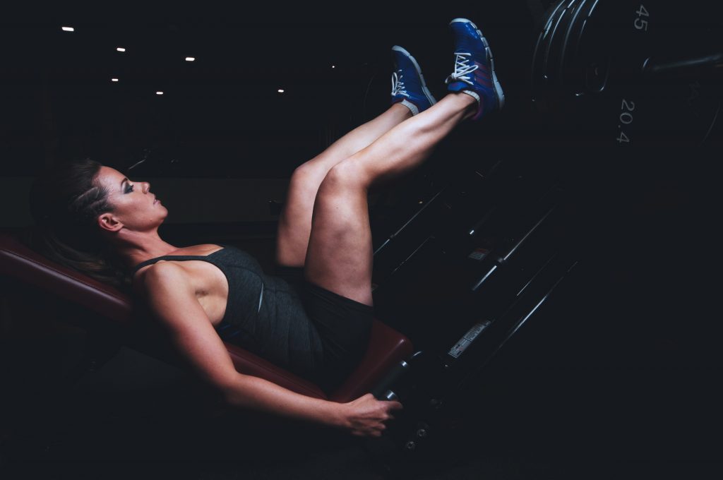 A fit woman on a leg press doing her booty building workout.