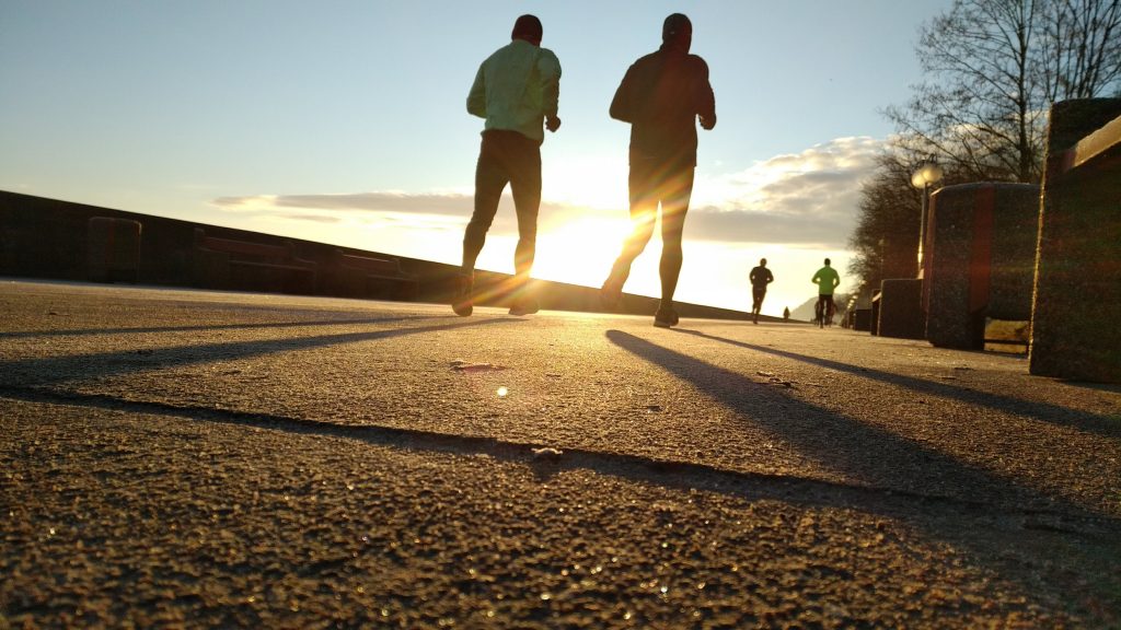 Two men jogging during sunrise. Avoid excuses for exercise.