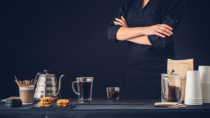 A woman next to a table with coffee mixture.
