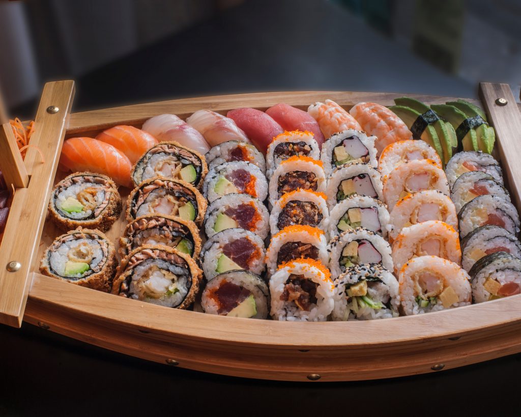 Assortment of sushi in a wooden boat platter. Looks amazing but is sushi healthy for you?