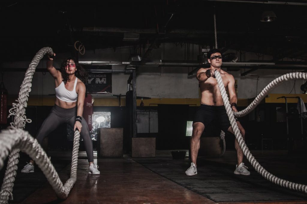 A man and woman holding a battle rope