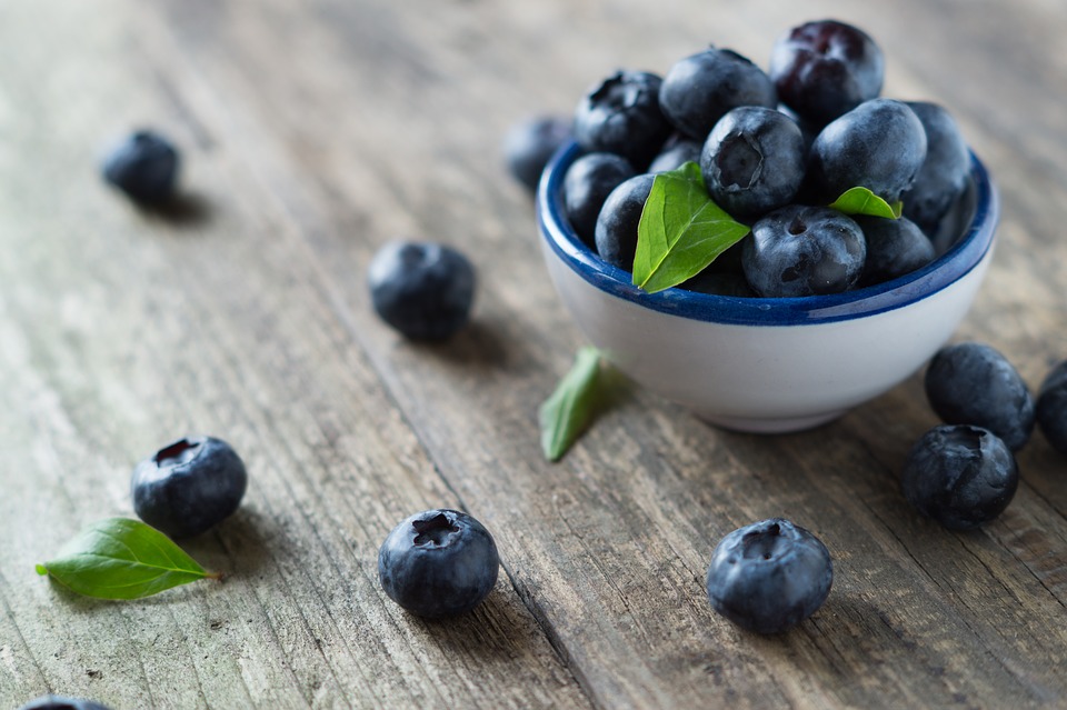 Blueberries in a bowl on a wooden table.