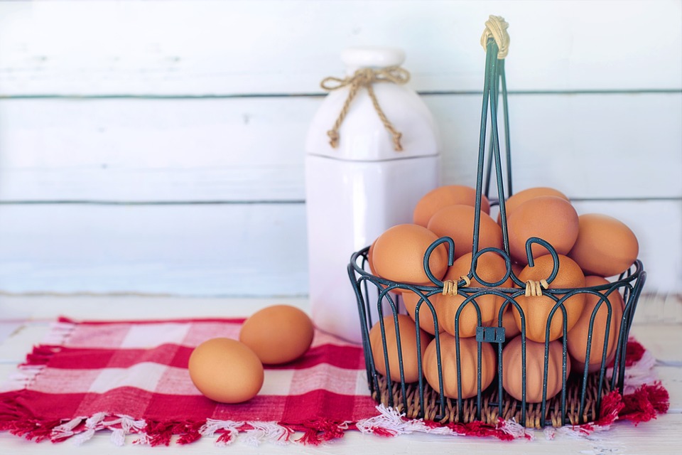 Brown eggs in a basket next to a jar of milk a good mood boosting food.