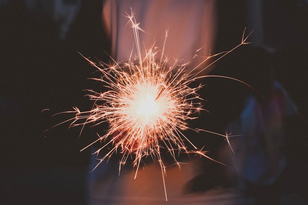 person holding a sparkler celebrating new year and the wellness trends. 