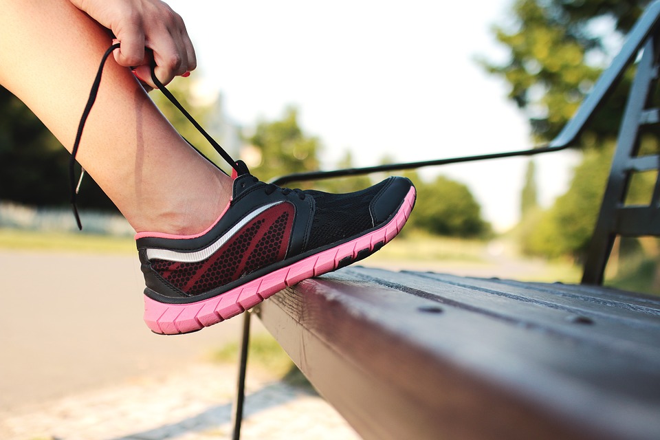 A person stopping to tie their laces while running. Would laceless sneakers save them time?