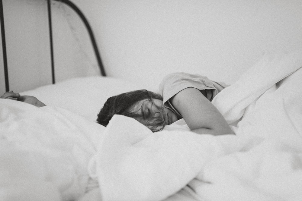A woman sound asleep on her bed. Myths about CBD as sedative.