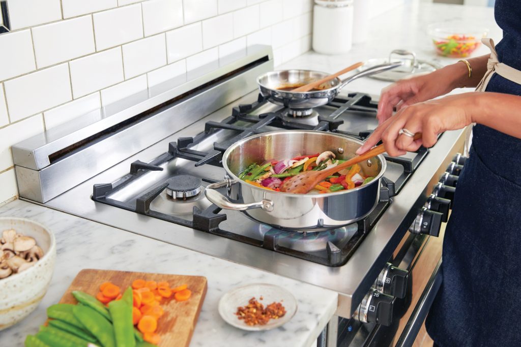 A woman cooking vegetables.
