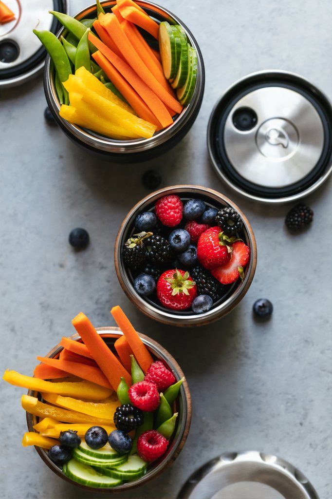 Three bowls of vegetables and berries.
