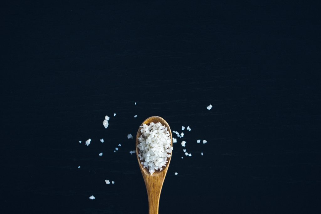 Wooden spoon filled with salt. 