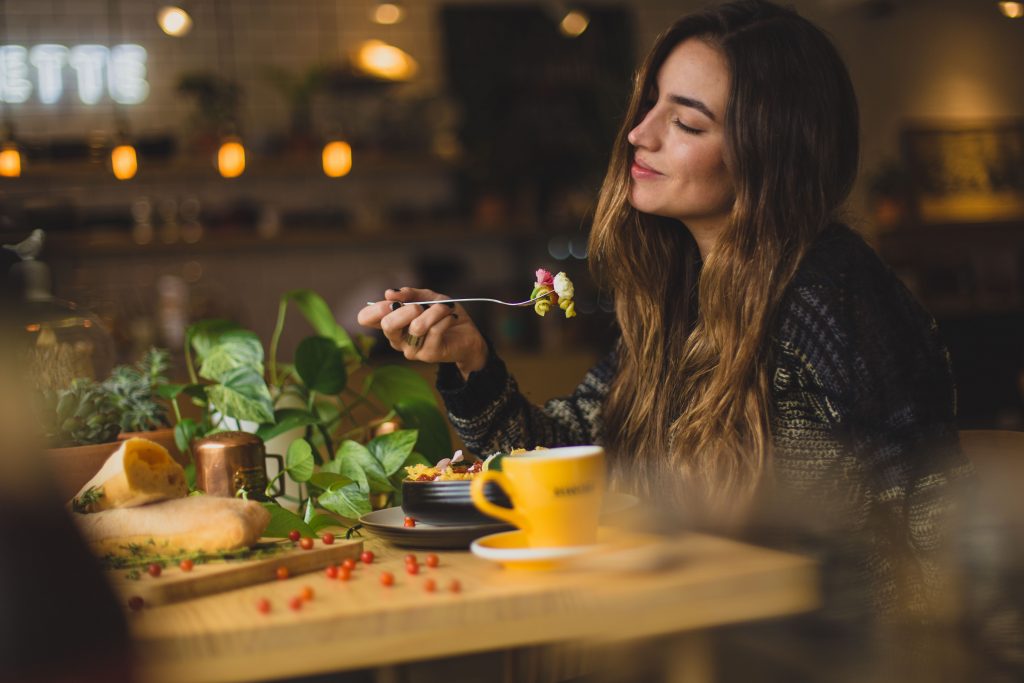 Women eating pasta at a table.