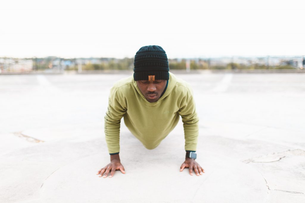 Man doing push ups outside.