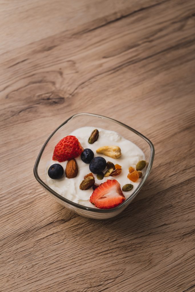 close up of a bowl of yogurt topped with berries and nuts
