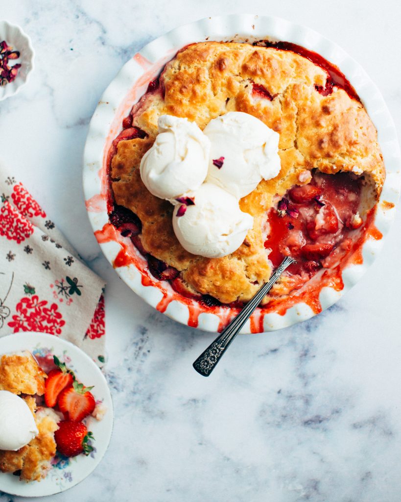 a bowl of vegetarian strawberry cobbler on a beautiful marble table