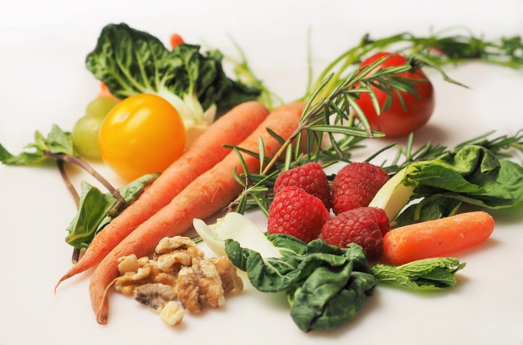 A close up shot of different vegetables, some berries and nuts. How to get healthy? Eat healthy and nutritious foods like these.