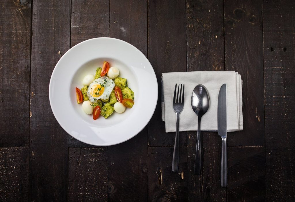 Sunny side up egg, boiled quail eggs, sliced red tomatoes, and sliced green bell pepper inside round white ceramic plate in a fine dining set. Is counting calories for weight loss really worth it?
