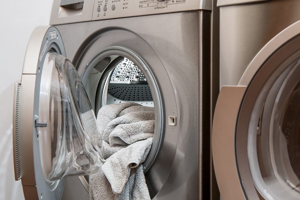 Washing machine with some laundry in it. Should you wash your workout clothes every time after gym session?