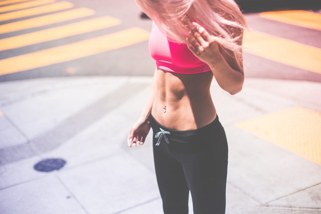 Woman looking down at her abs. 