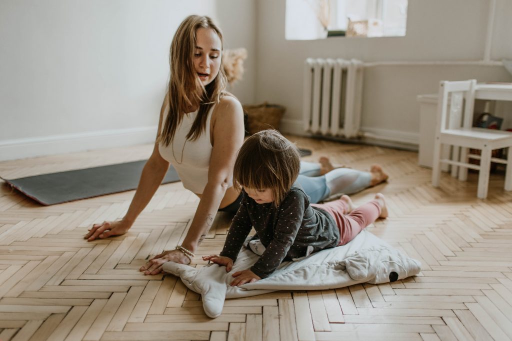 Mom and Daughter stretching on the floor.