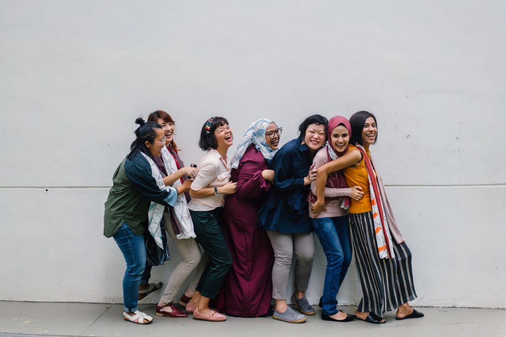 A group of women laughing while falling in line.