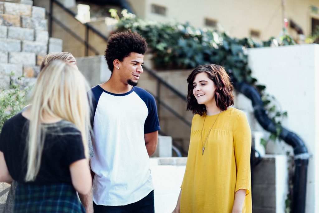 A man having a conversation with 2 women. How does connecting with other people play into life's purpose?