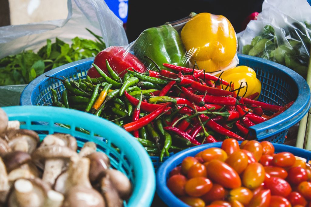 Baskets of chillis, tomatoes and mushrooms.