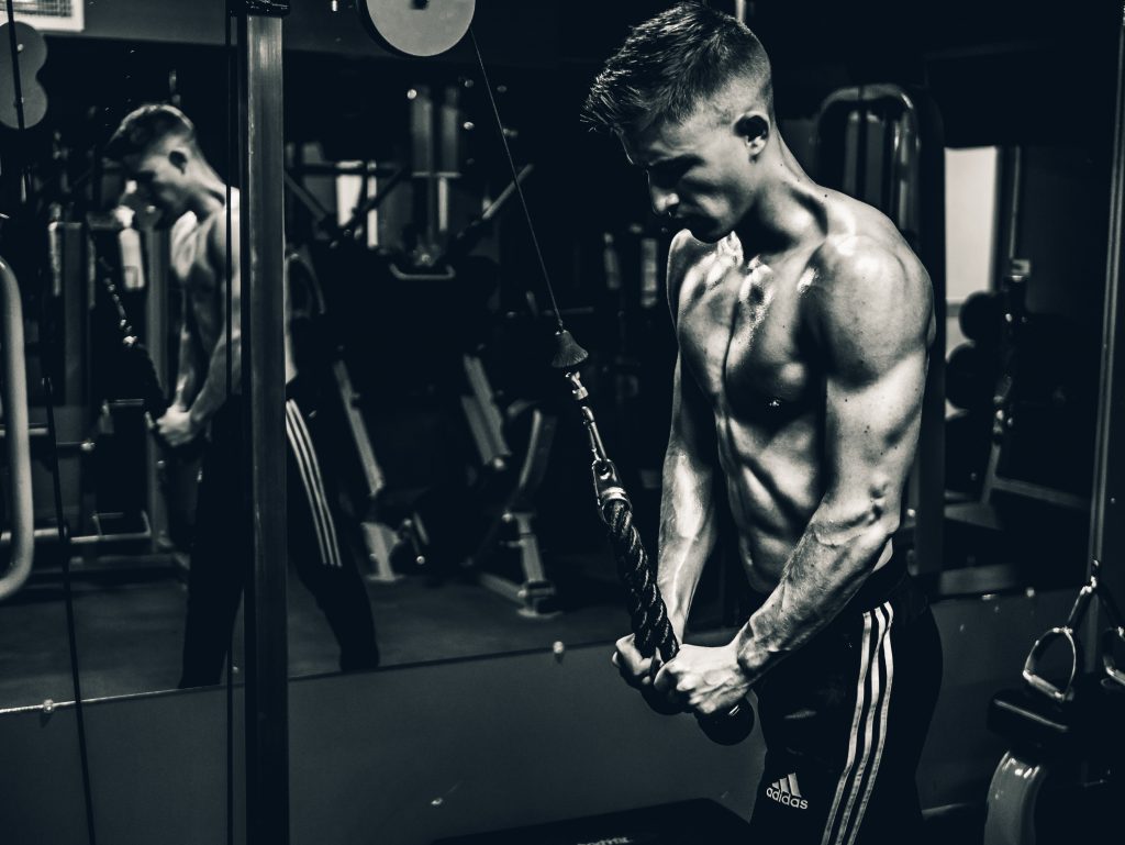 Man doing tricep workout in gym.