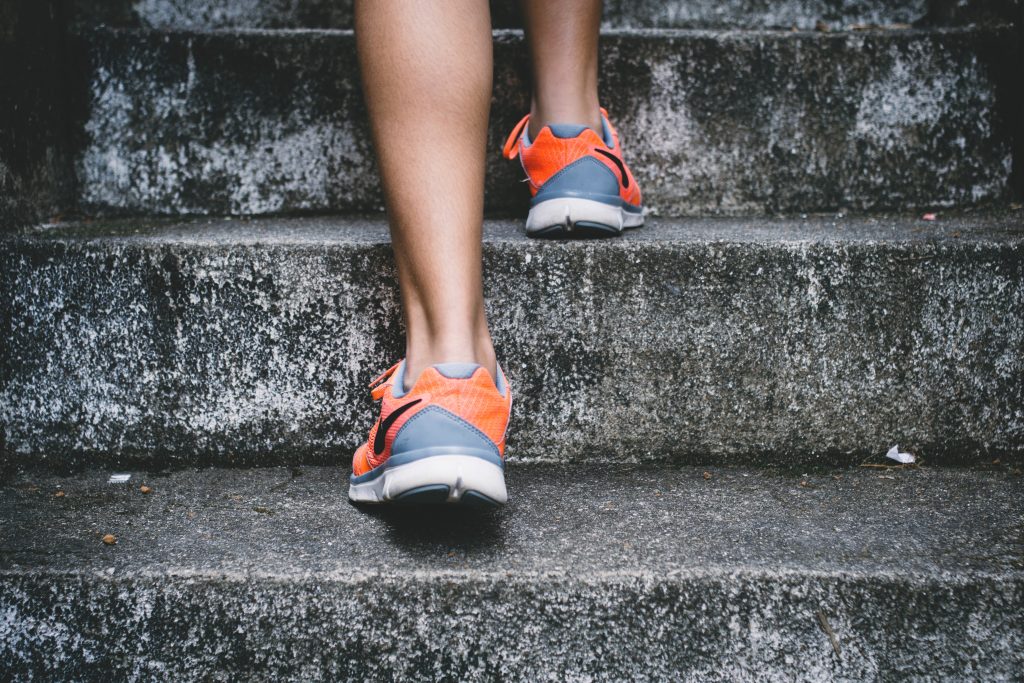 Close up of sneakers walking up steps.