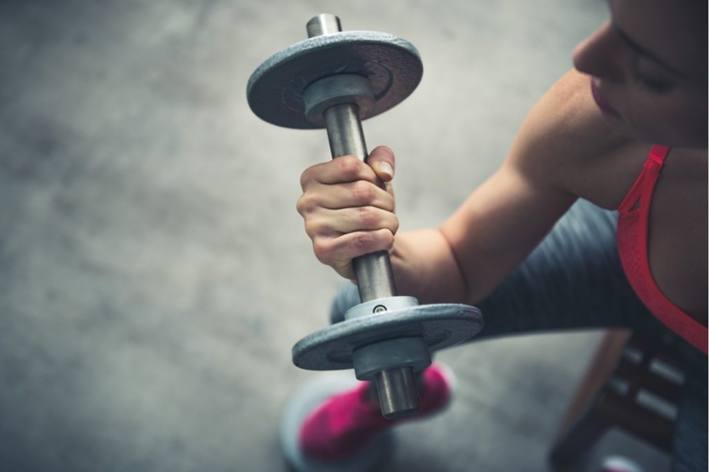 A woman lifting a dumbbell.