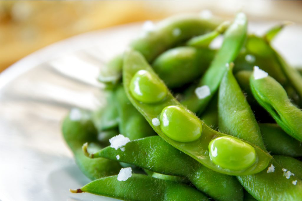Japanese edamame beans on white plate.