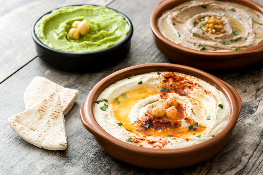 Different types of hummus in bowls.