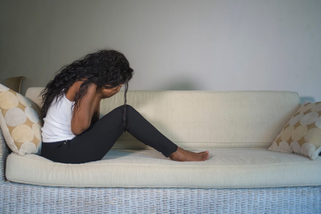 Lonely looking woman crying on a couch.
