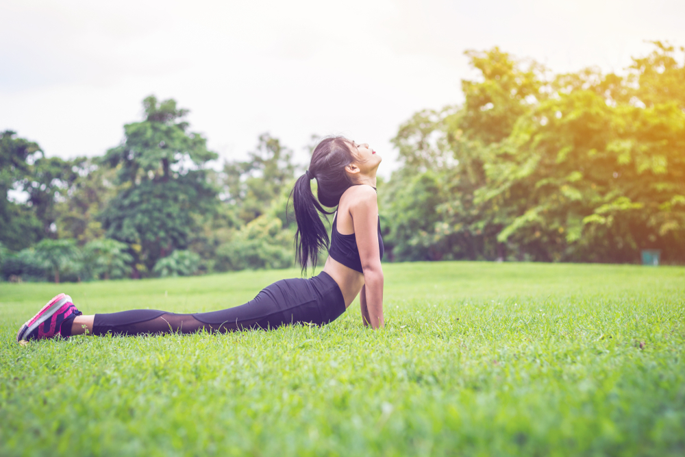 A woman doing yoga with nature as background.