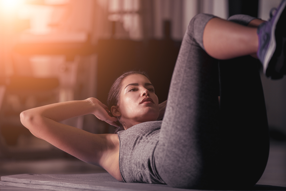 Woman doing abs workout. How to achieve goals by examining your feelings.