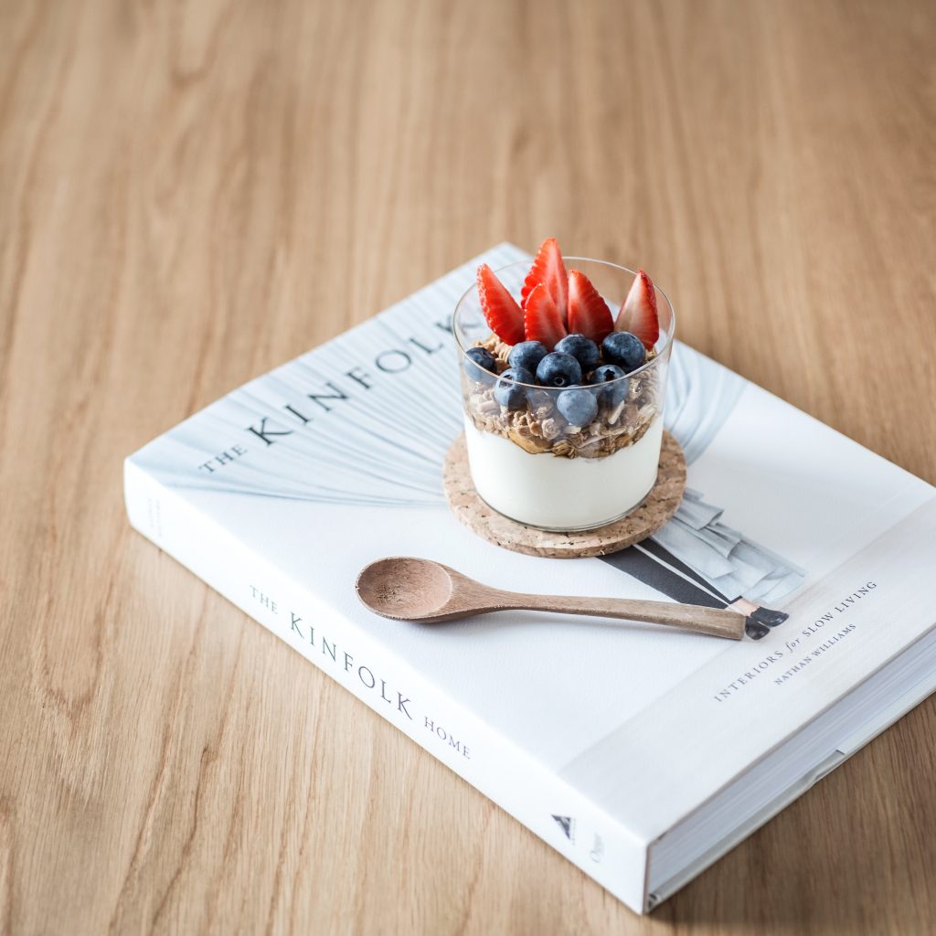 Yogurt in a glass on top of a book.