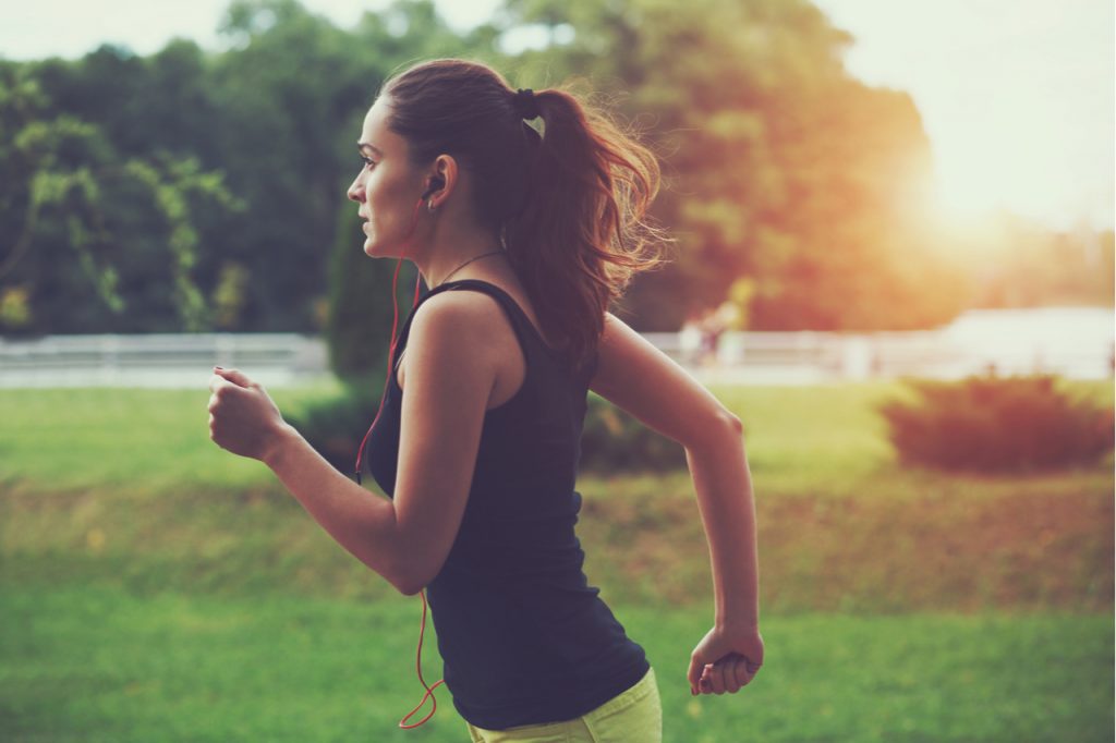 Woman jogging in the morning while sun is rising.