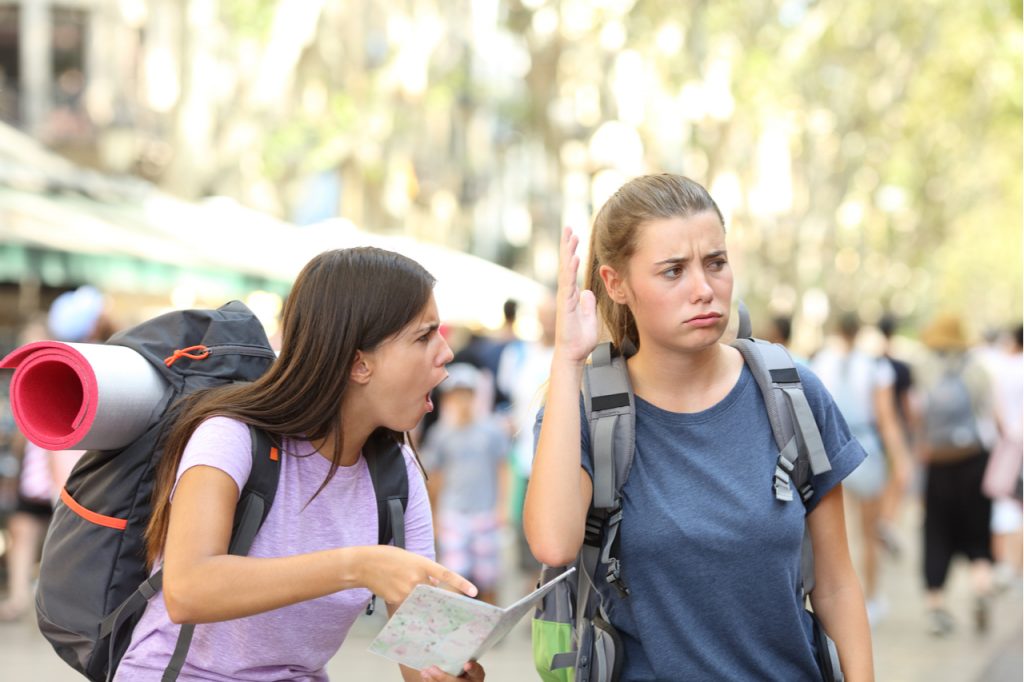 Two woman having an argument and one raised her hand to show that she is not interested in listening.