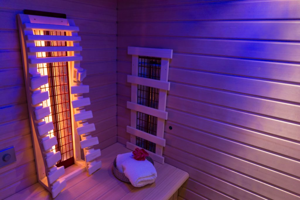 Feel the benefits of infrared sauna by looking at this image of an infrared sauna room in dim lighting.