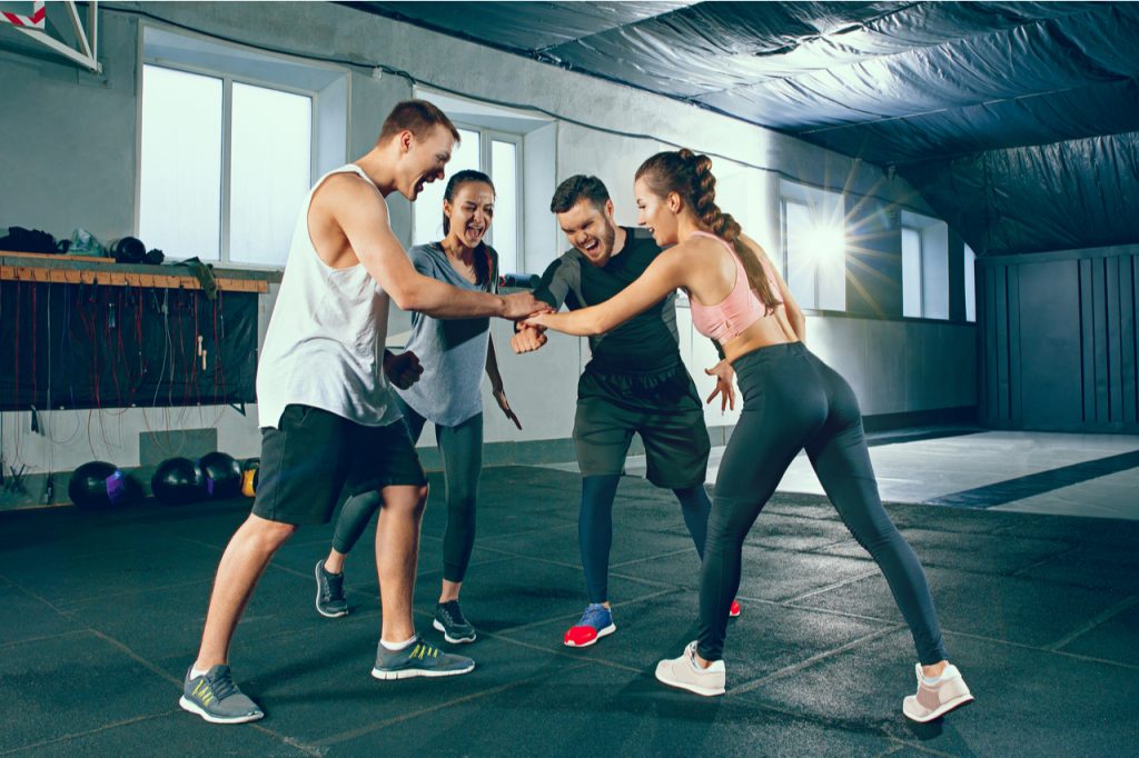 Group of friends ready to do a high-five to take on a challenging workout together.