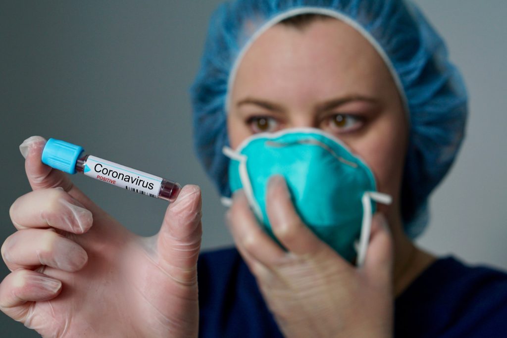 medical worker holding vial of Coronavirus. Coronavirus update and latest developments.