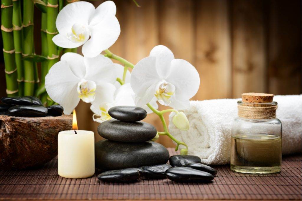 Stone, essential oil, a towel, a flower and a candle light.