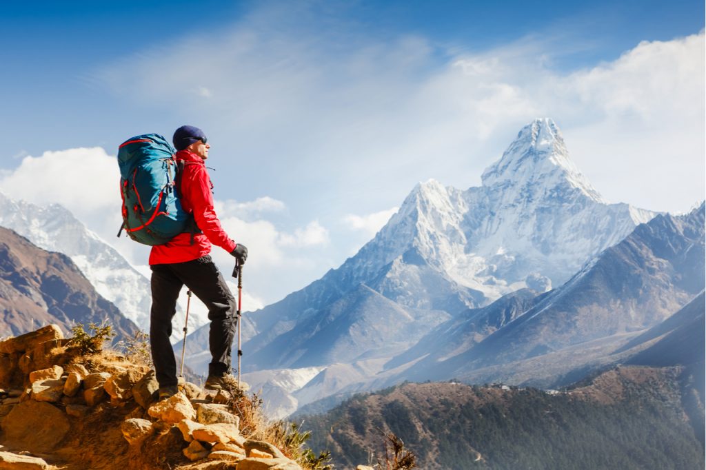 A man who just reached the top of a mountain while hiking.