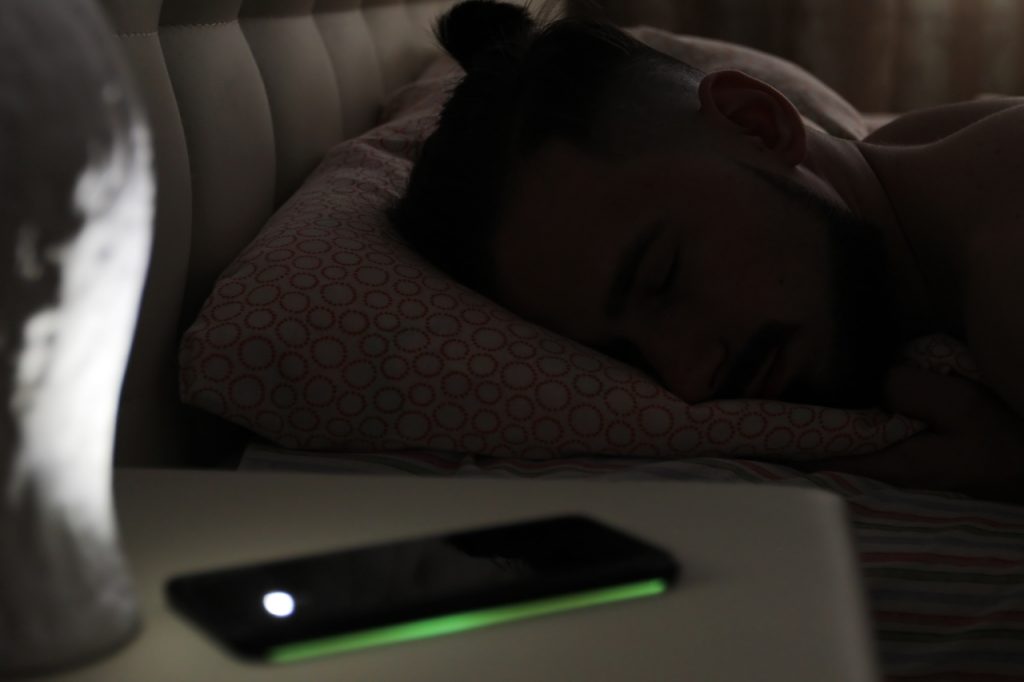 A man sleeping with his phone turned off.