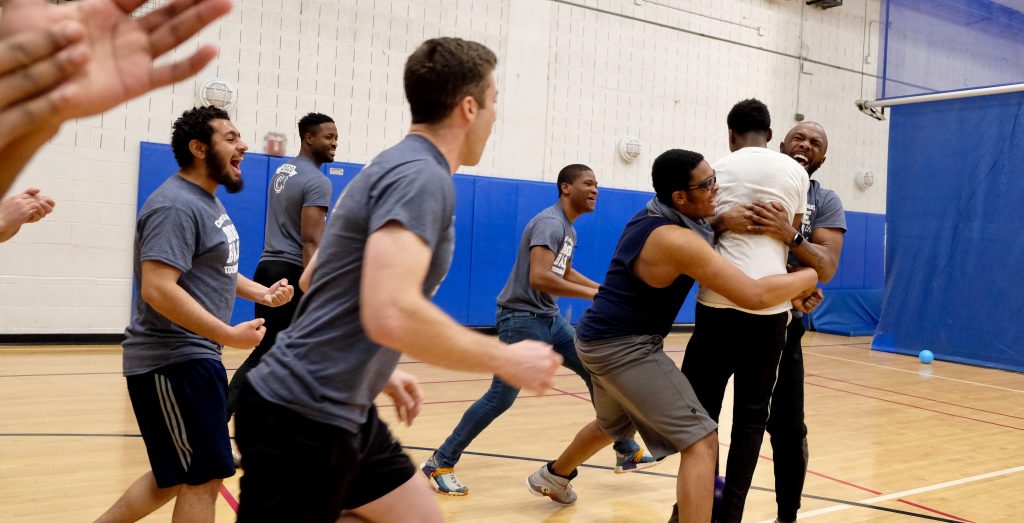 Coney Island Prep boys on a basketball court with their coach