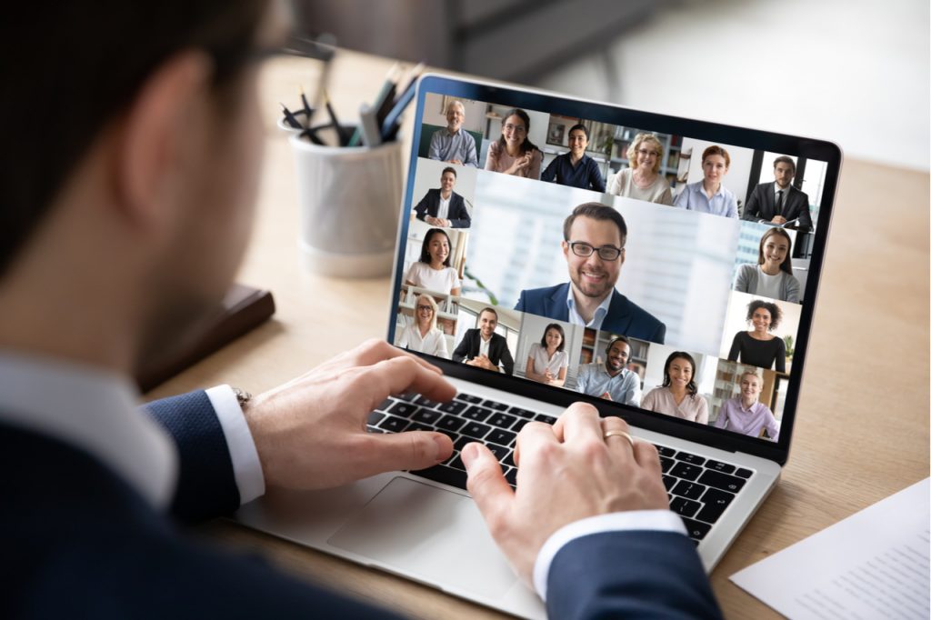 Conference with diverse colleagues using laptop webcam to stay connected.