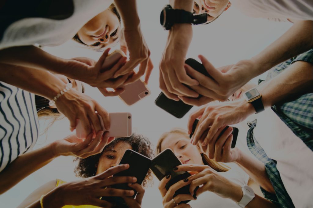 A group of people looking at their phones doing social media.